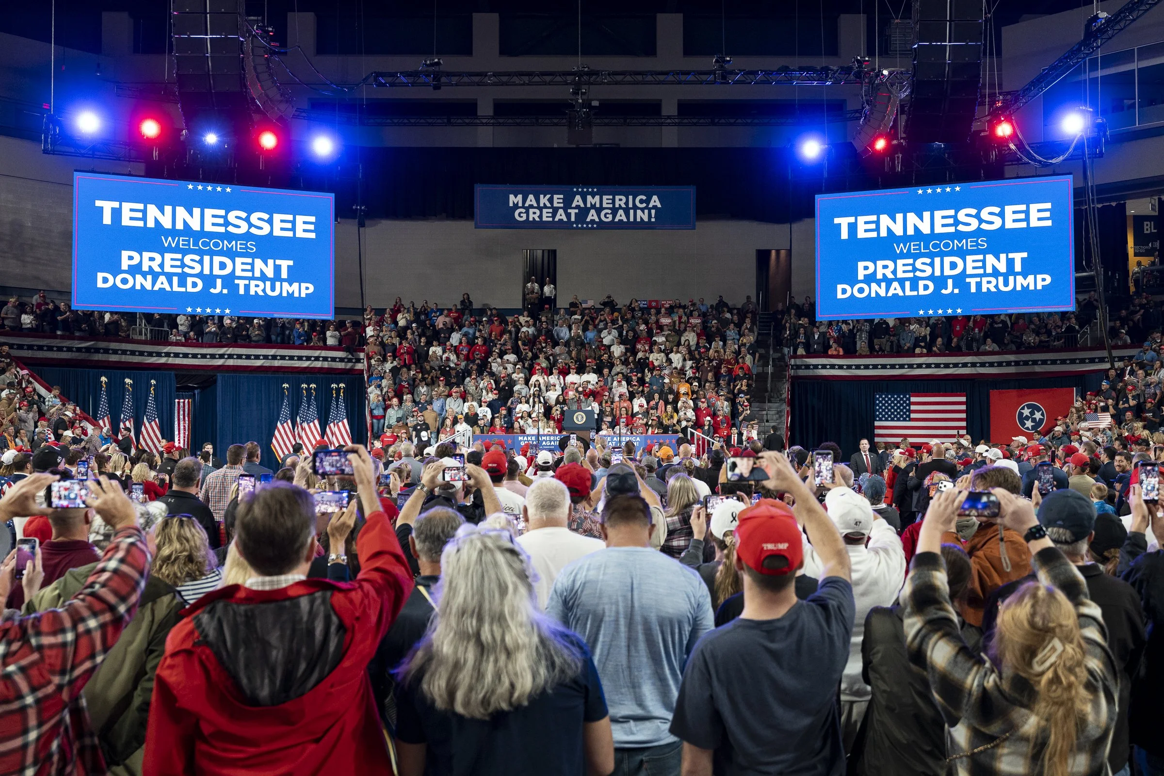  Crowd members hold up their phones as President Trump is introduced.  