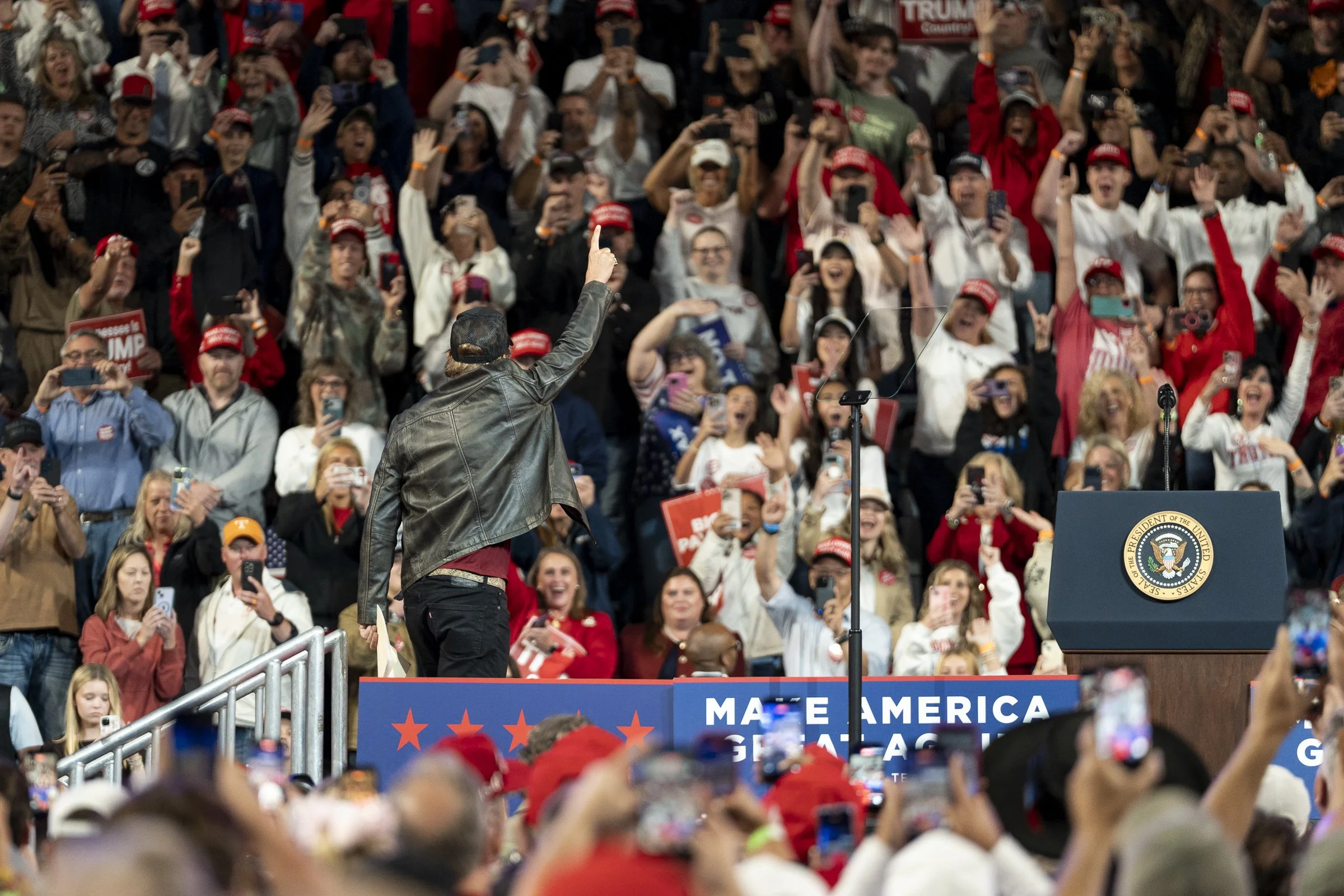  Musician Kid Rock raises one finger as he approaches the podium while the crowd cheers. 