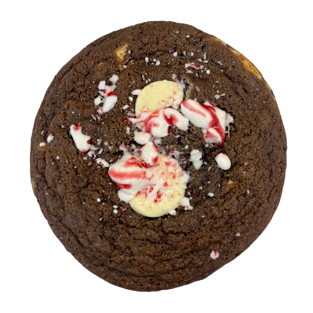 A cookie with white chocolate chips, colorful sprinkles, and white chocolate discs on top.