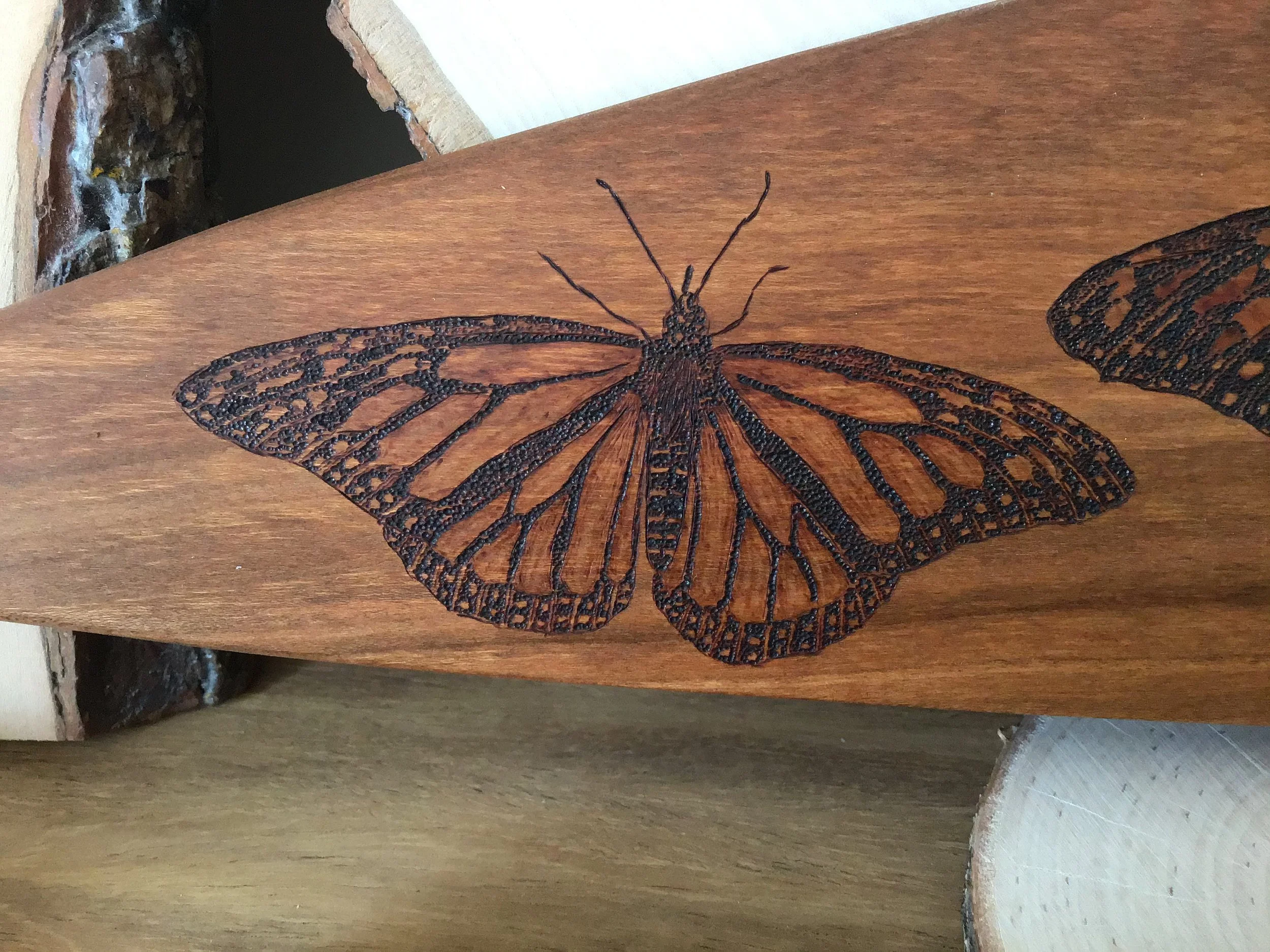 monarch butterfly on wooden paddle