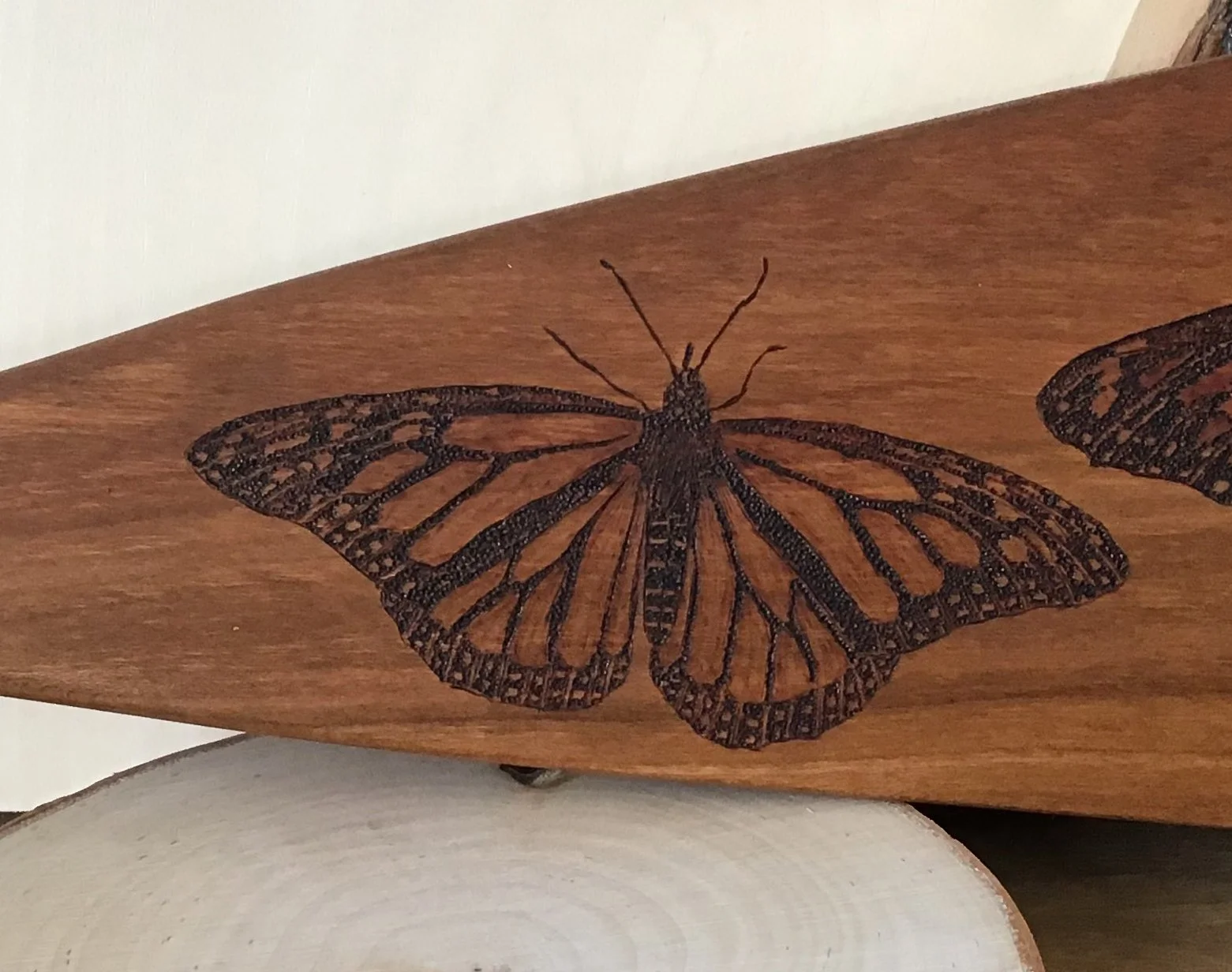 monarch butterfly on wooden paddle