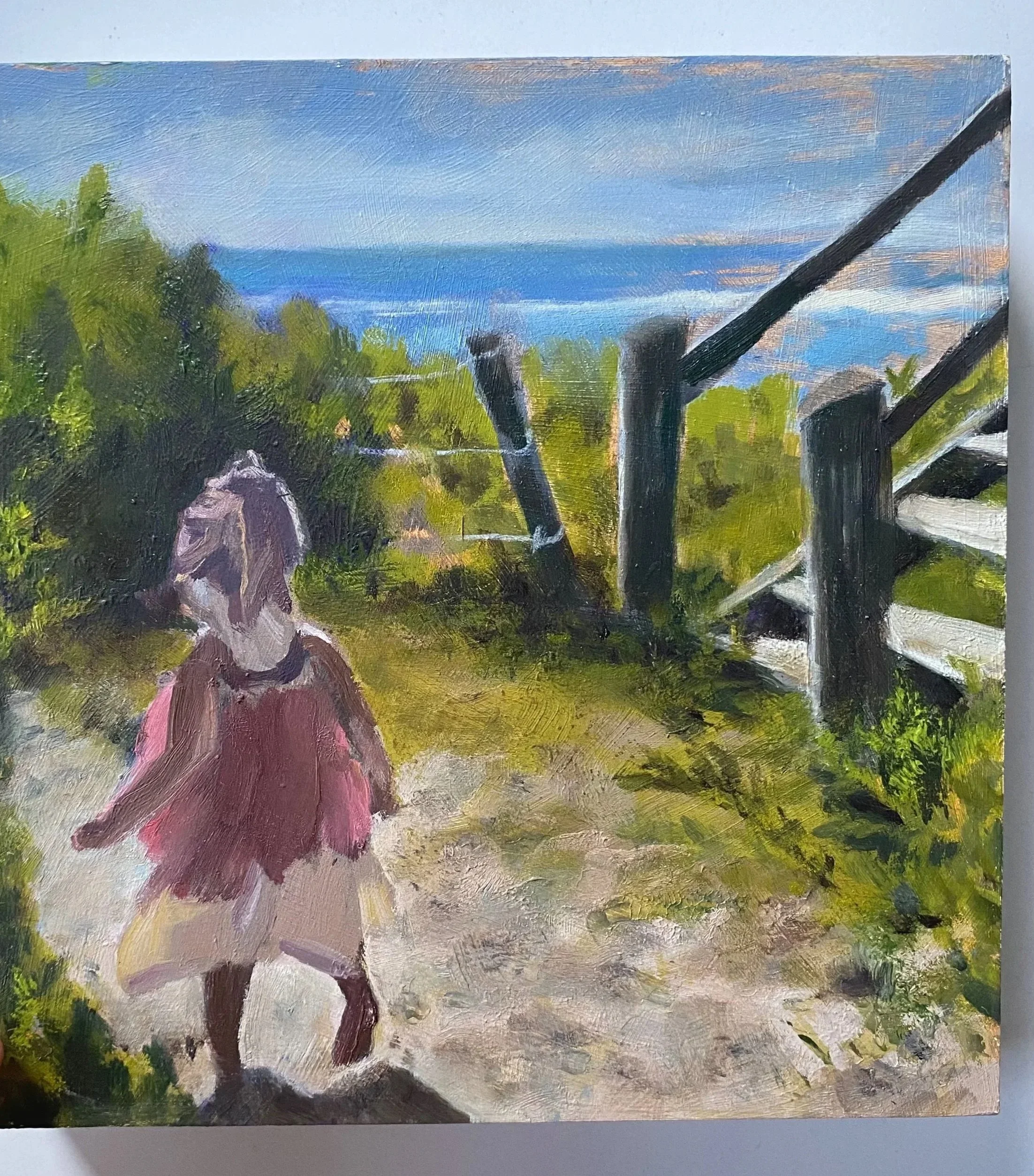 Halo in the sunlight - A young blonde girl skips down the sandy path to the beach