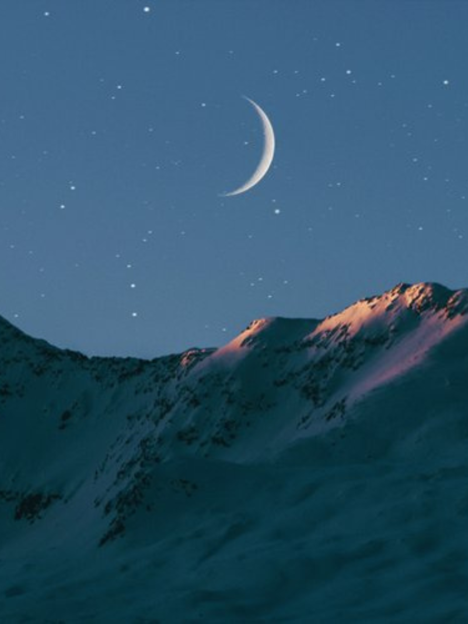 Snow-covered mountain peaks under a starry night sky with a crescent moon.