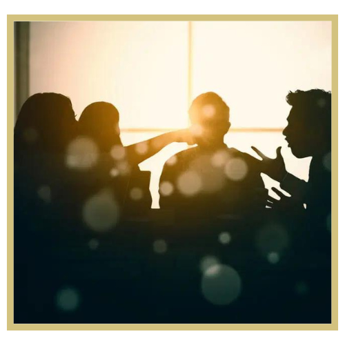 Silhouettes of four people in a room with sunlight coming through the window, engaged in conversation.