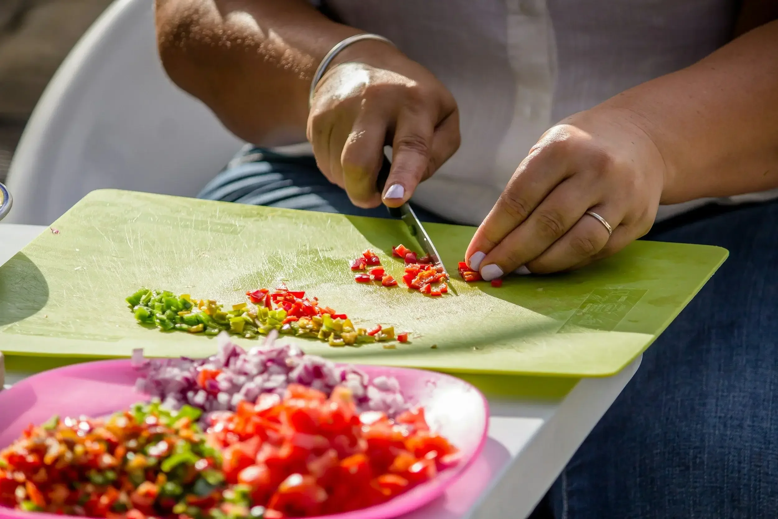 Person chopping vegetables on cutting board during daily living support activity