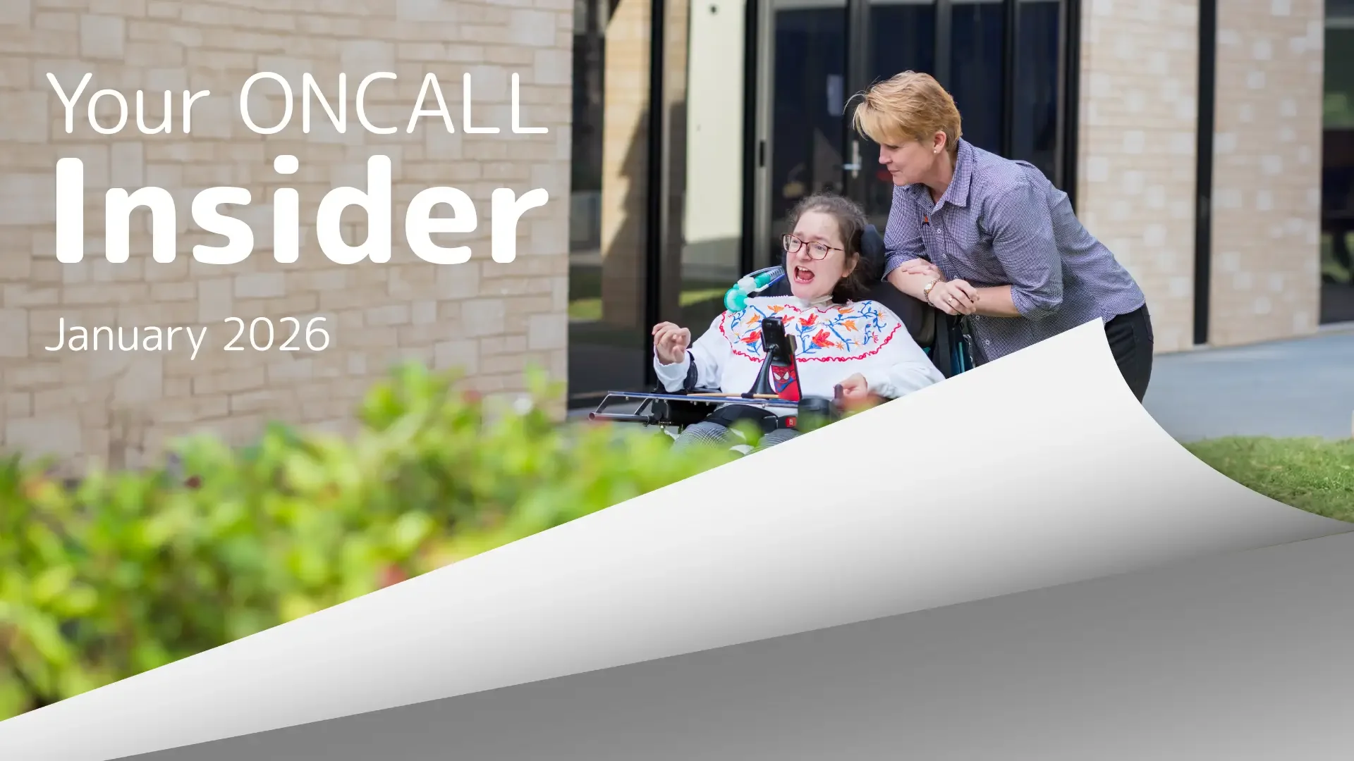 A woman using a wheelchair is supported by a carer outdoors, representing personalised in-home disability care and support services.