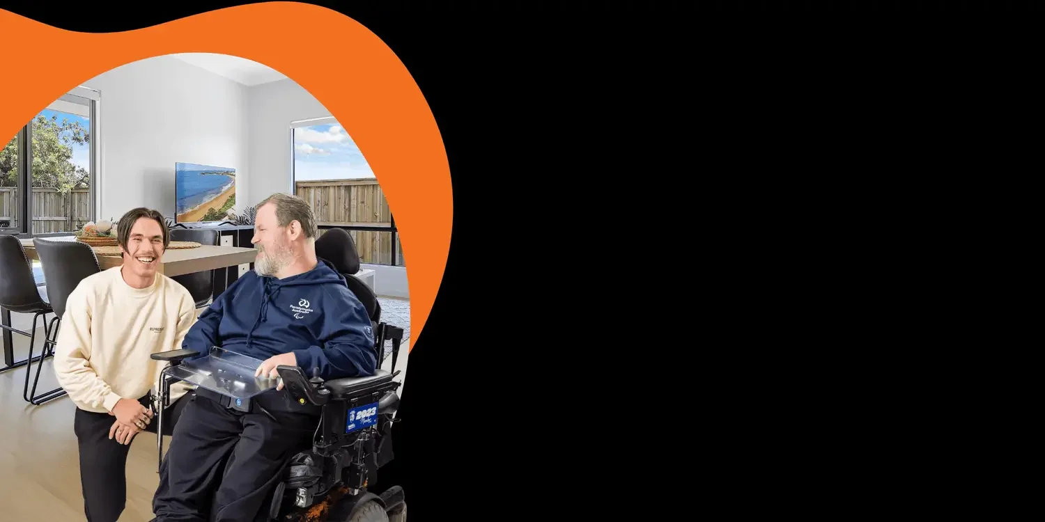 Support worker assisting man in wheelchair inside accessible home