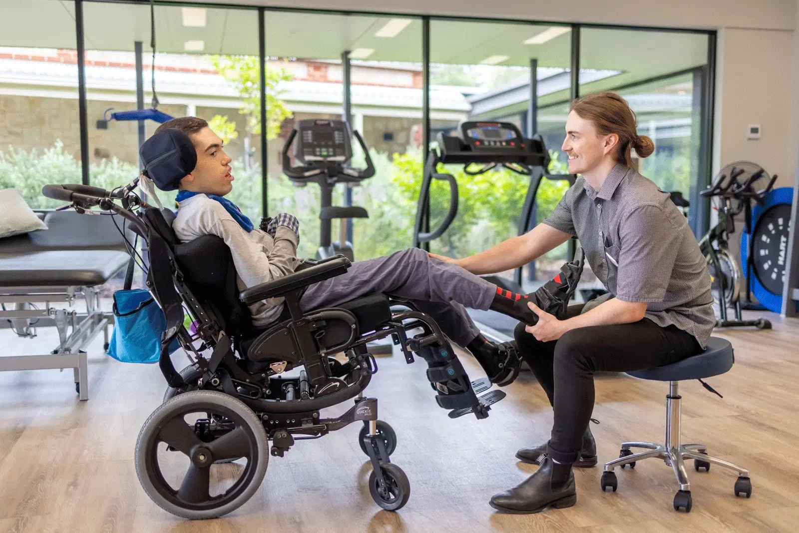 Physiotherapist supporting a wheelchair user during a therapy session