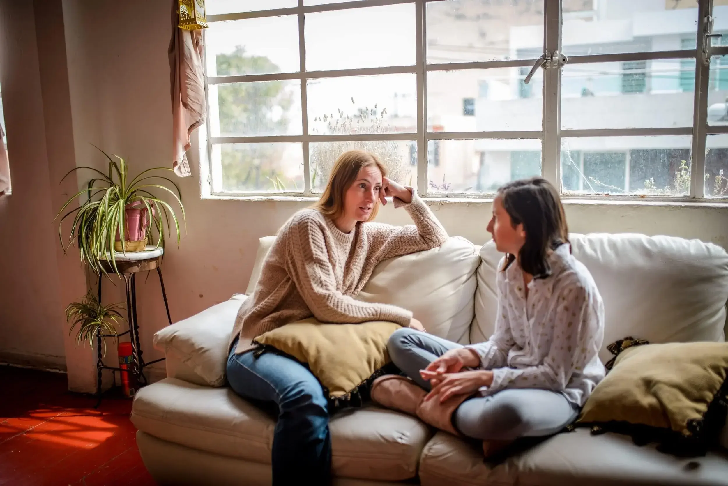 A woman and child talking on couch in supportive home care environment