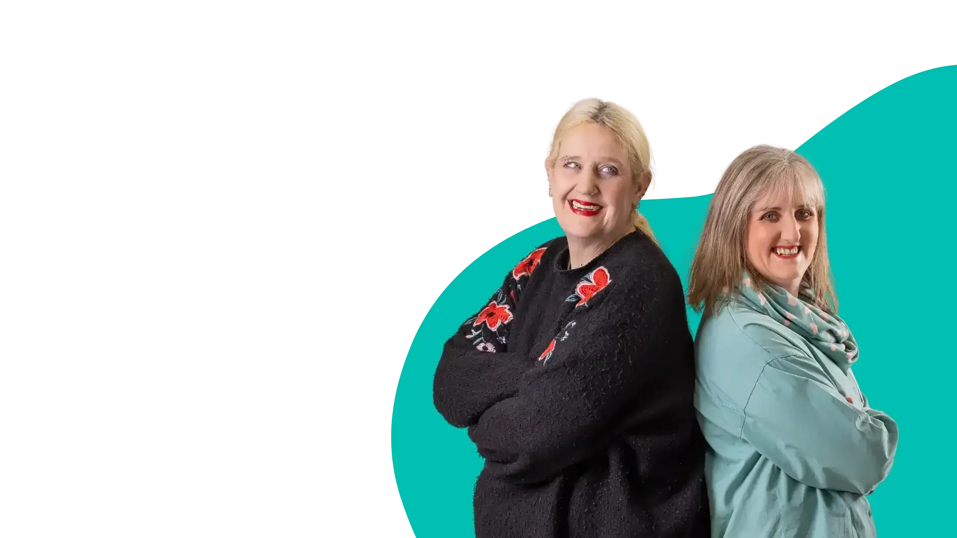 Two women standing back-to-back smiling against green background