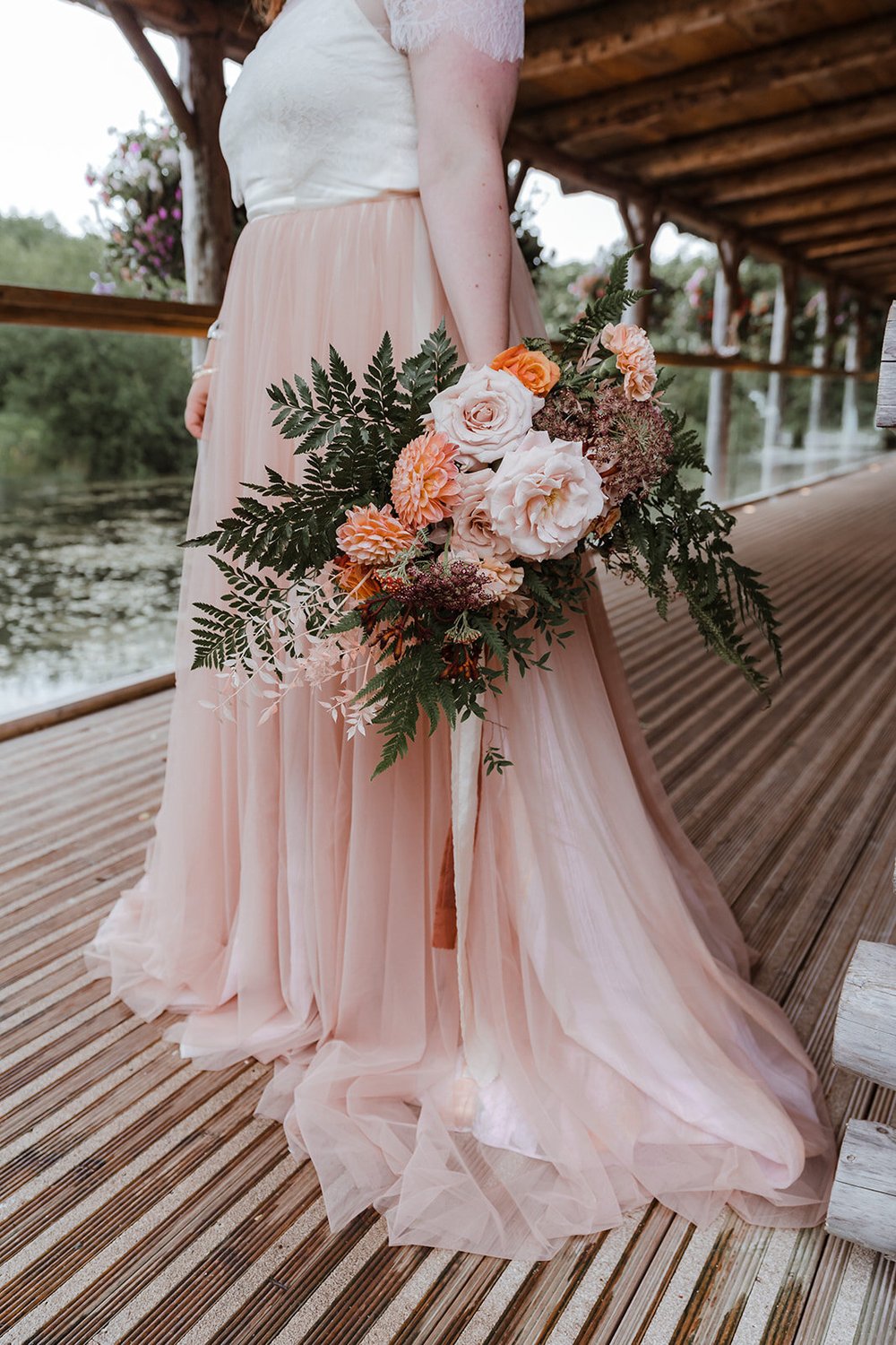 plus size bride in pink wedding dress with wild fern bridal bouquet 