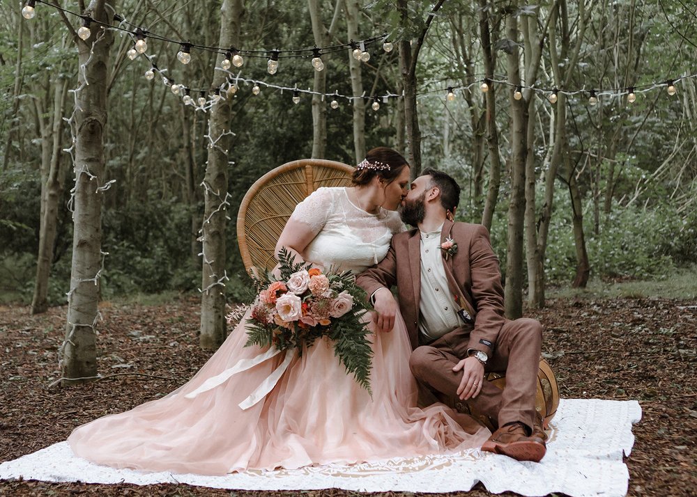 woodland wedding portrait with pink wedding dress on plus size bride and festoon lighting