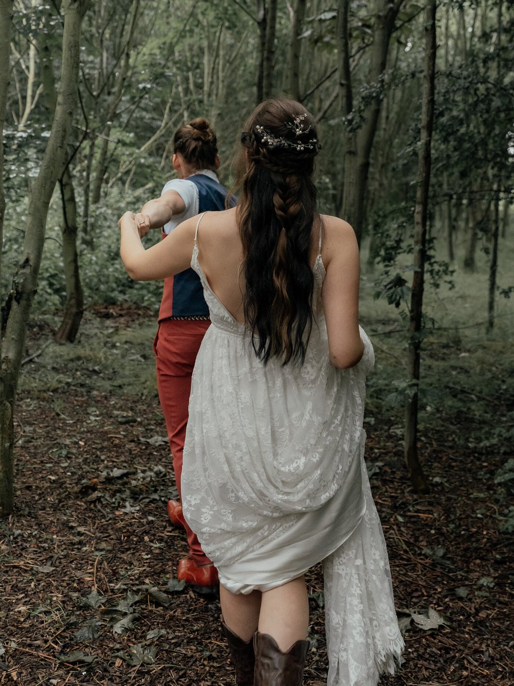 groom leading bride into the forest for a wild elopement
