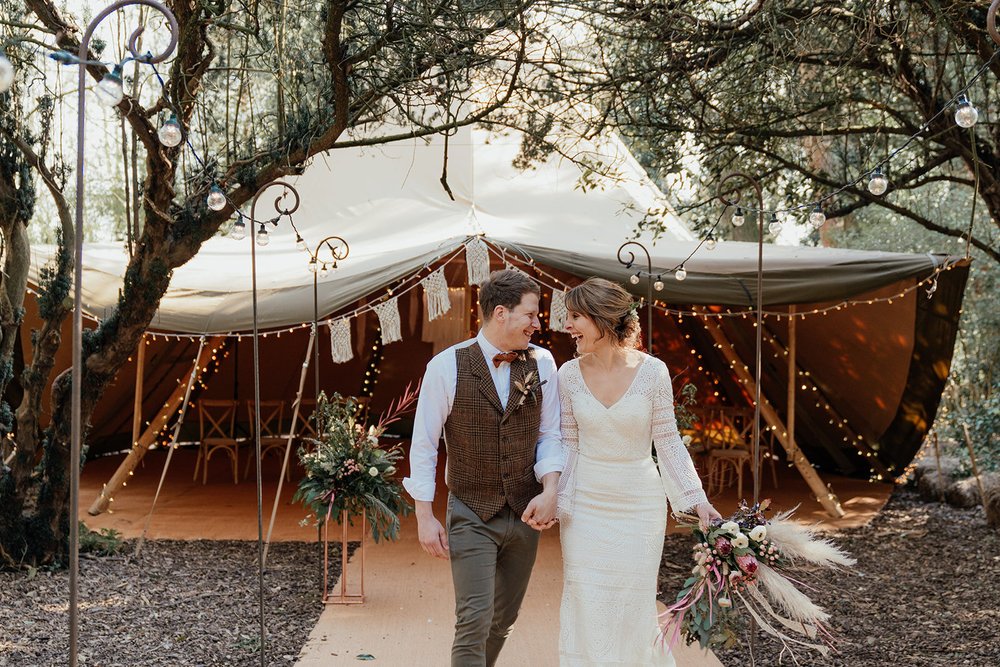 bride and groom exit their tipi wedding with crochet wedding dress