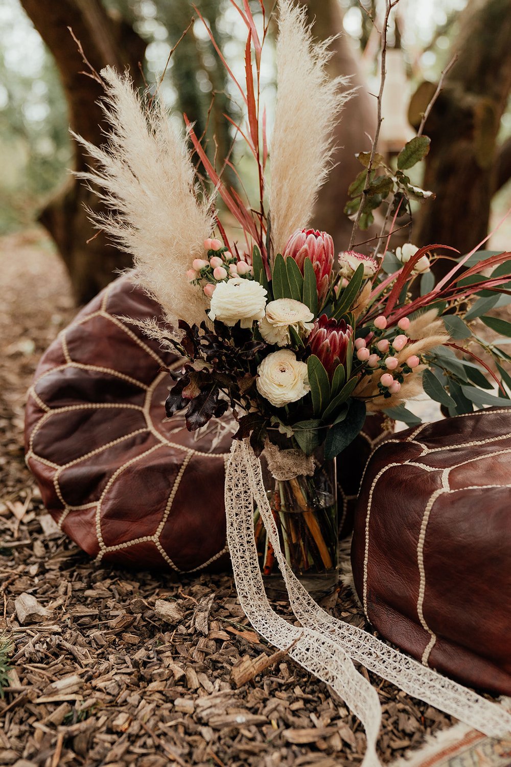 moroccan leather pouffe wedding decoration with wild handtied bouquet with natural ribbon and pampas grass