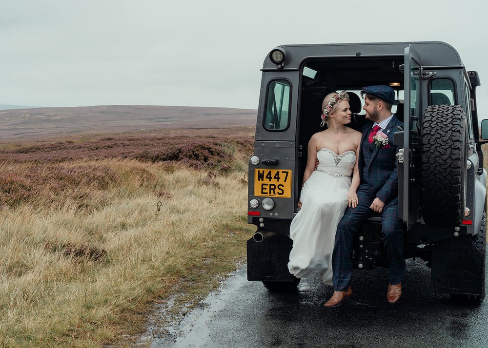 boho couple in the back of a landrover defender
