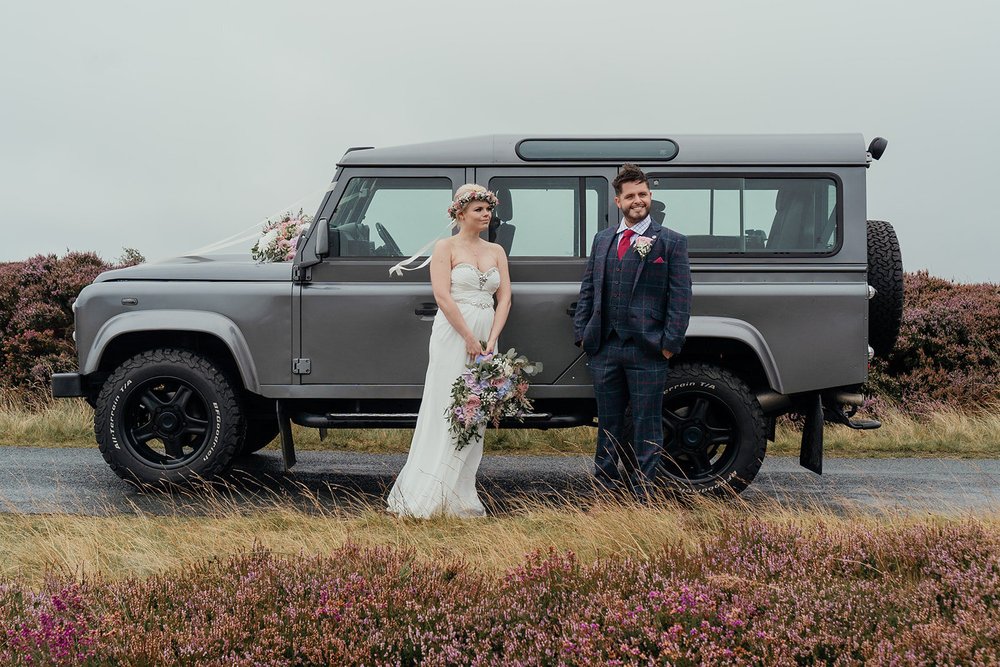 bride and groom on the yorkshire moors with landrover defender
