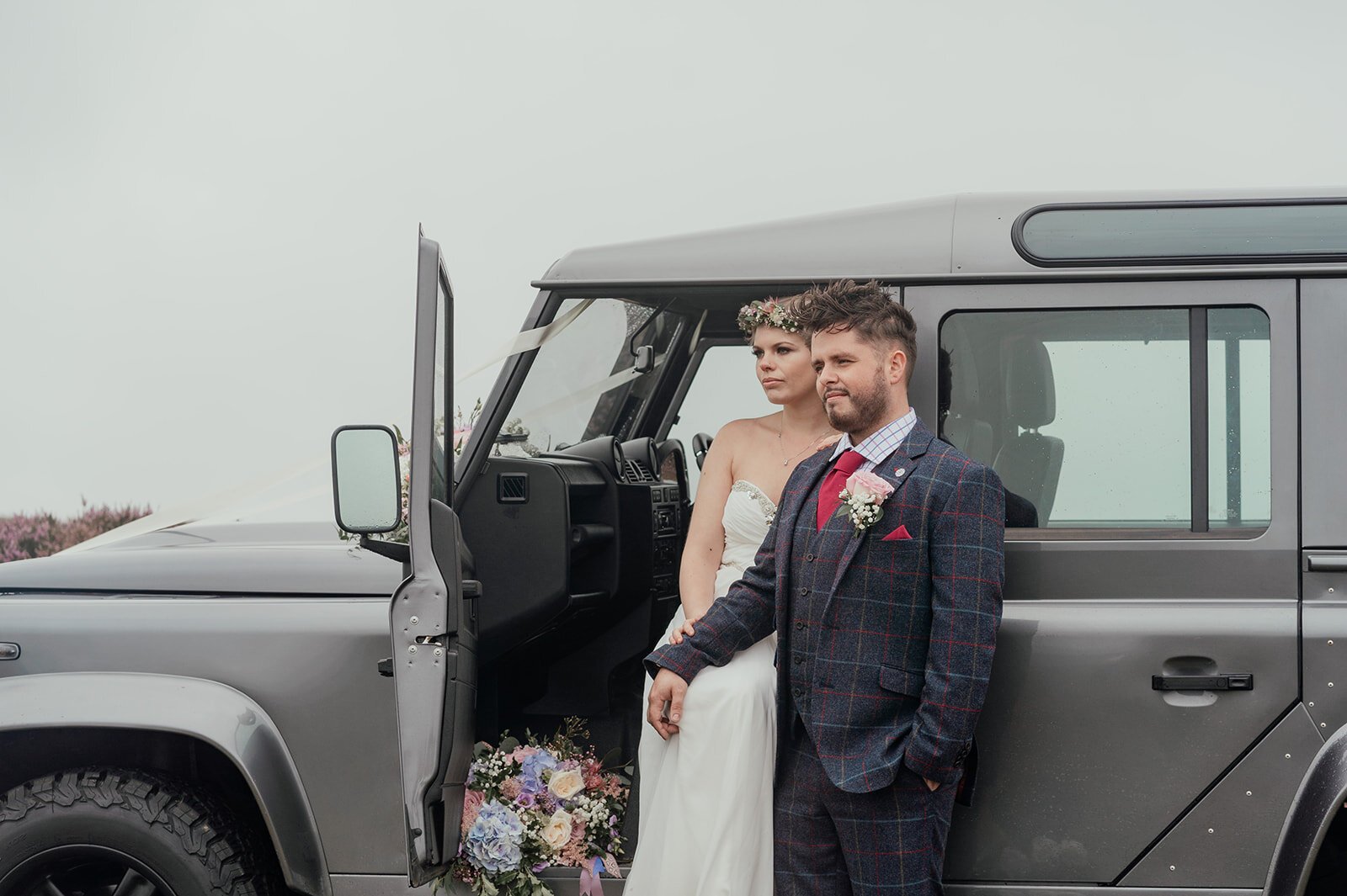 countryside flowers and tweed suit with landrover defender wedding car