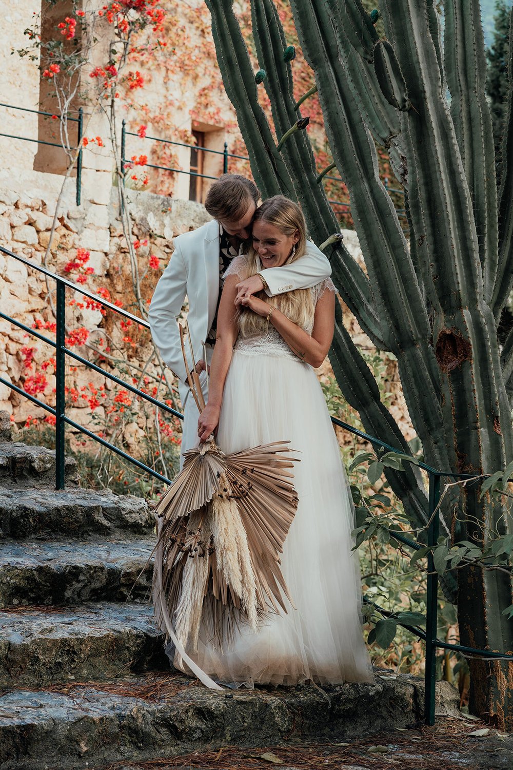 dried palm leaf bridal bouquet with boho couple in front of cactus at island wedding