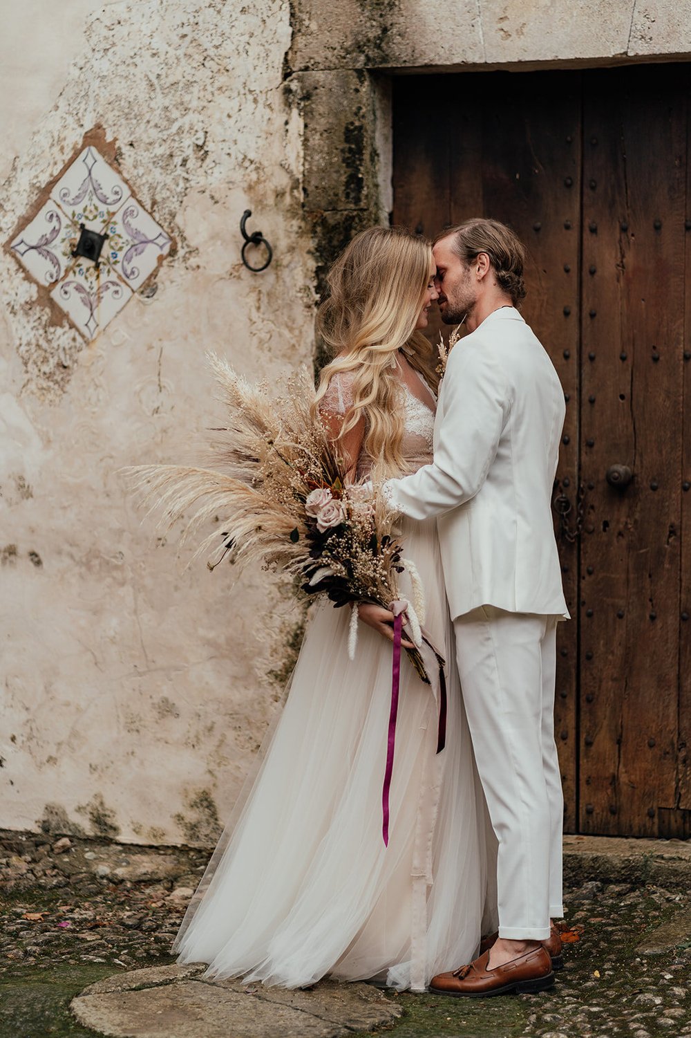 white groom suit with wild dried flower bridal bouquet