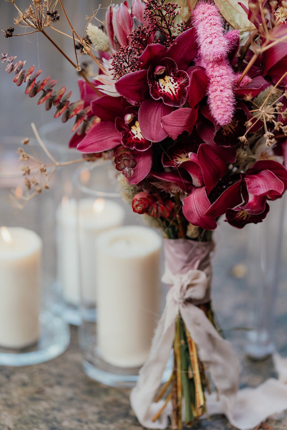 pink orchid bouquet with candles in hurricane jars