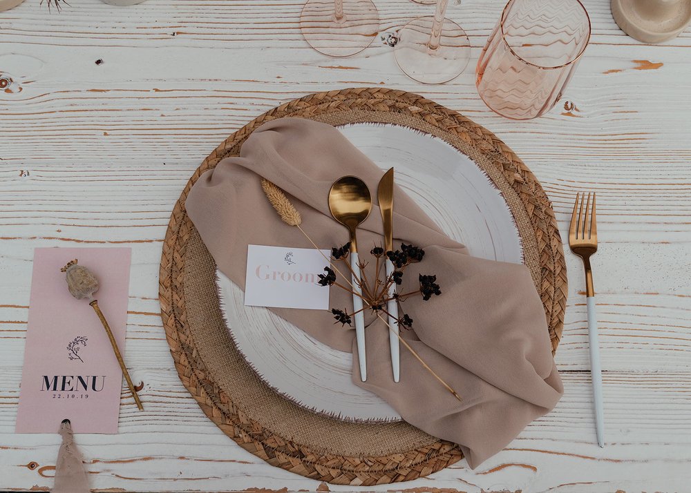 flatlay table place setting with gold cutlery and pink menu card