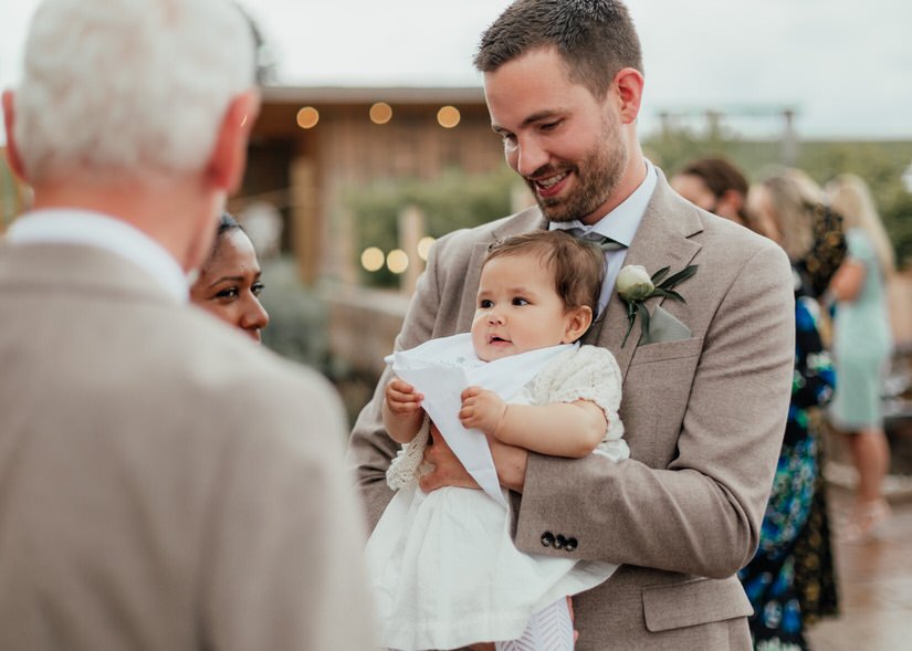 groomsman holding his baby girl