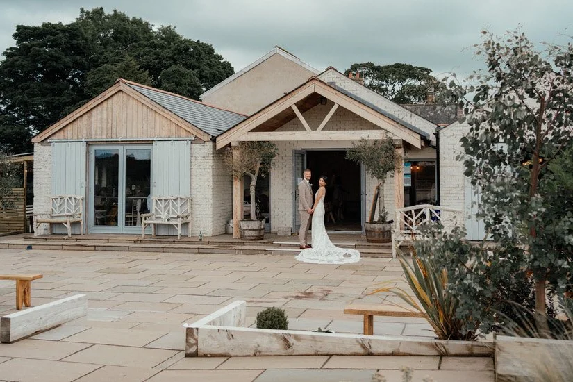 bride and groom outside the doors of their wedding venue, Eden Barn
