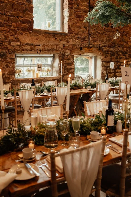 barn wedding breakfast venue with tables set for dinner with candles