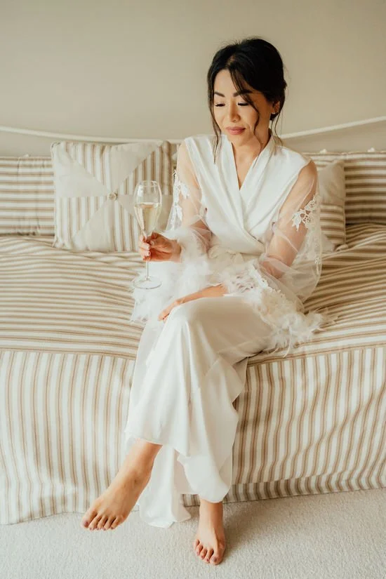 bride in a bridal dressing gown with a champagne glass
