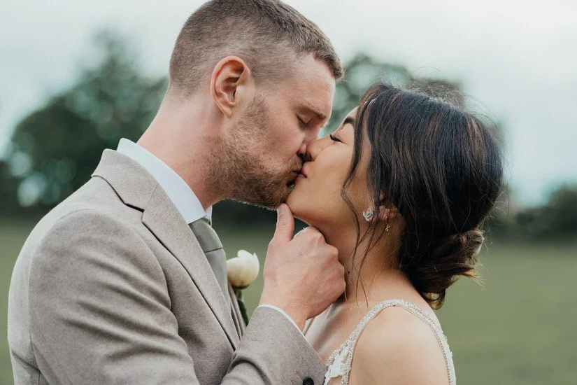bride and groom kissing with his hand holding up her chin