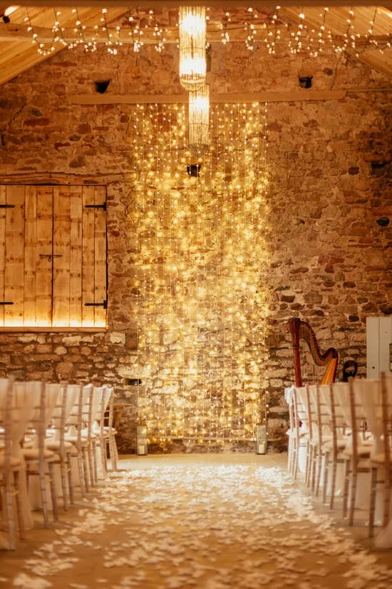 rustic wedding ceremony barn with fairy light backdrop