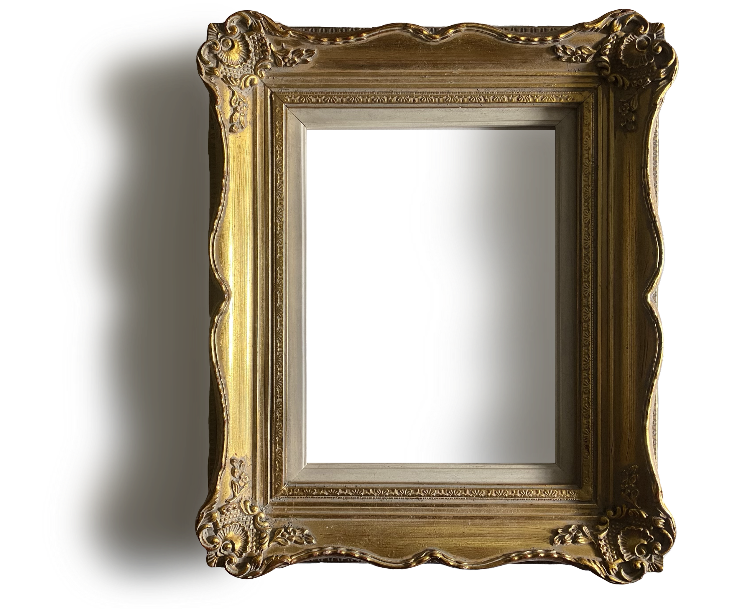 Cadre de miroir antique avec ornements dorés et détails floraux.