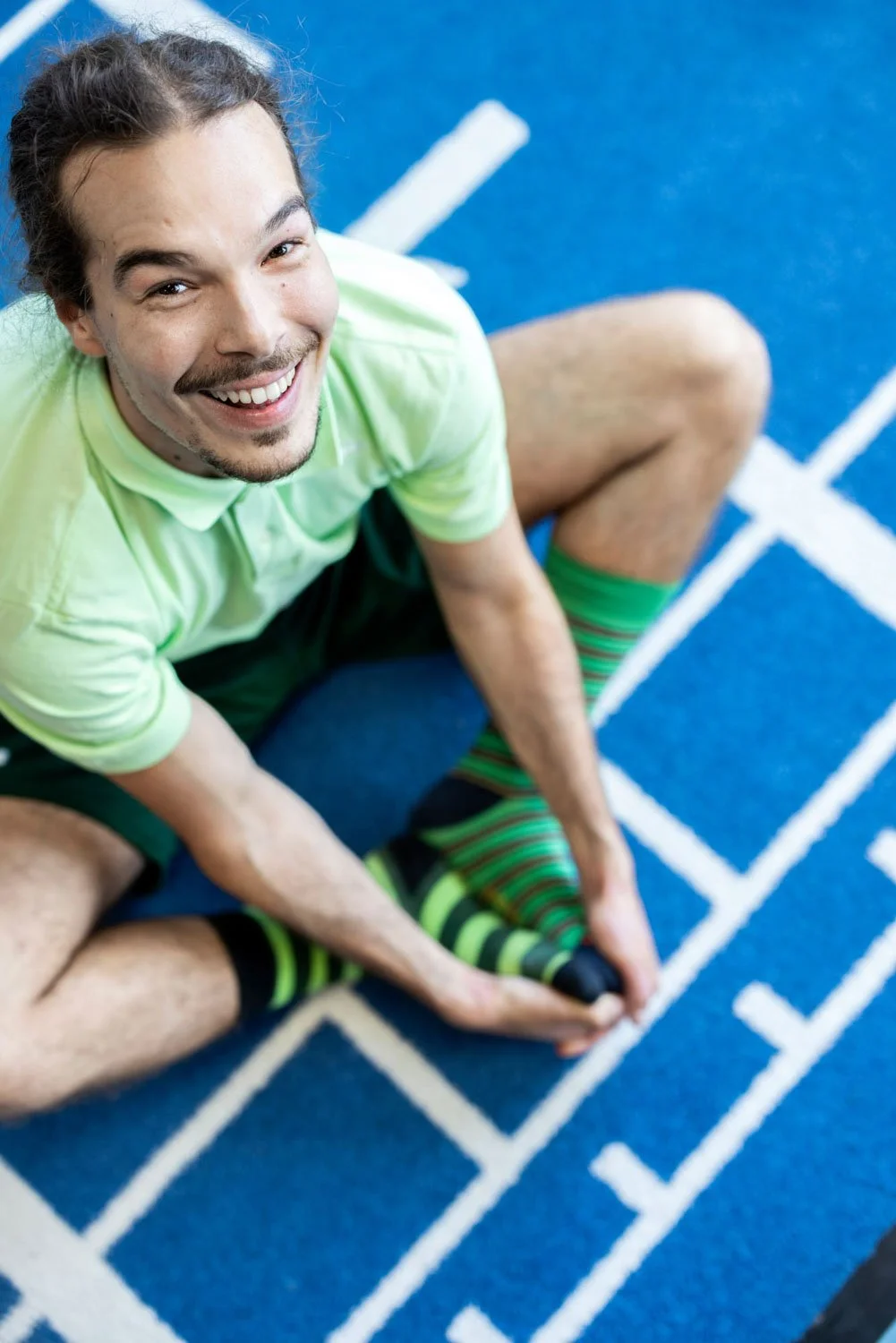 Henkilö katsoo kameraan, samalla venytellen ja hymyilee.
