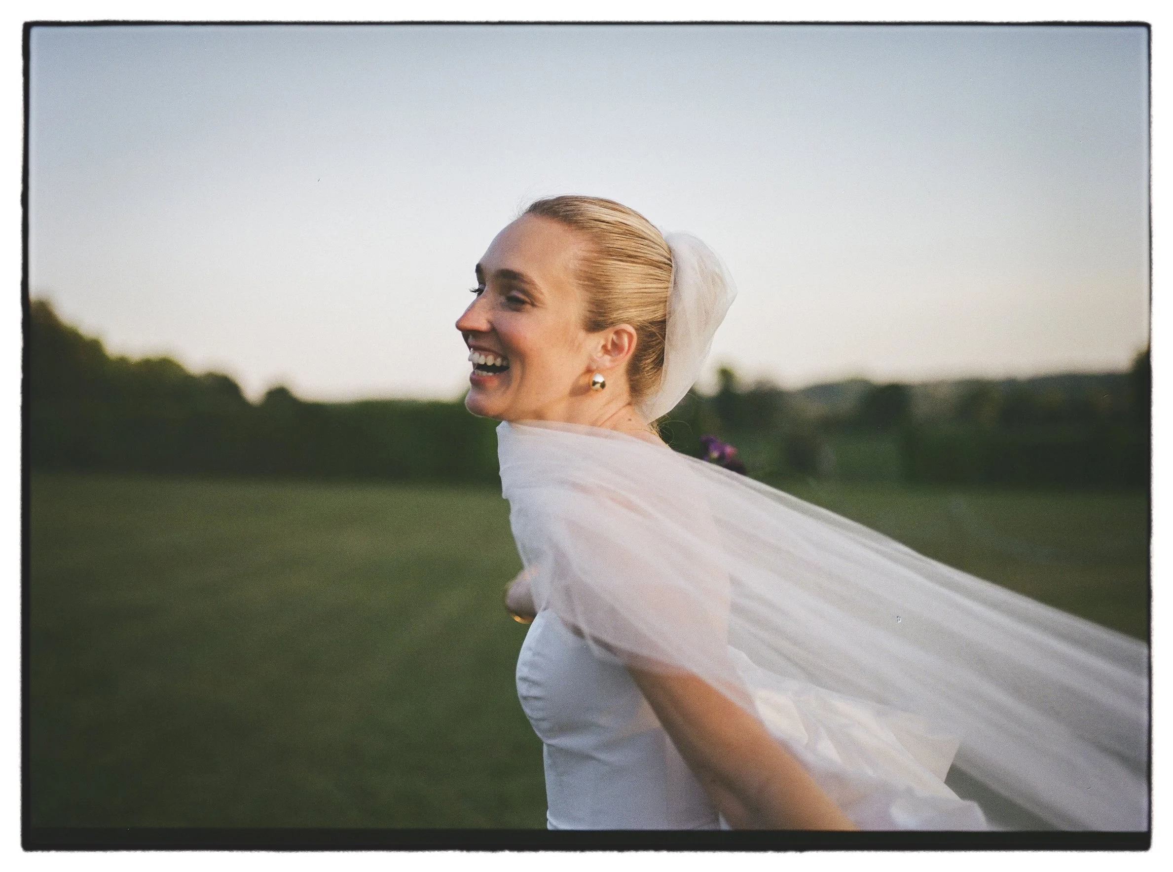 Bride running in the blue hour with her veil over her face