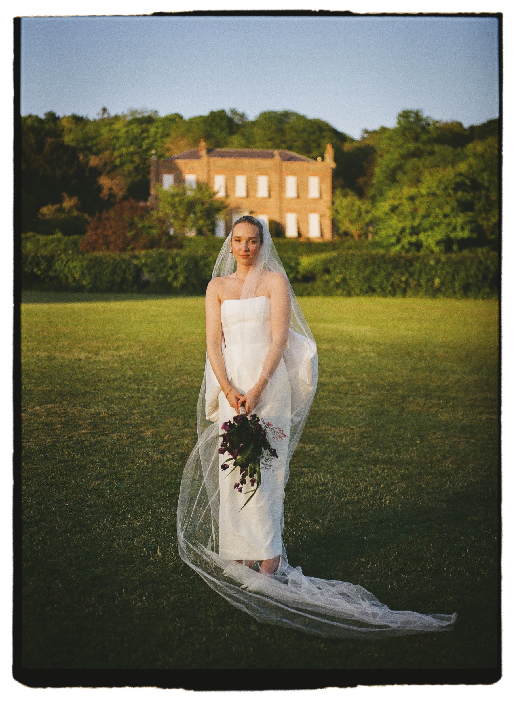 Henley On Thames wedding bride in golden hour wearing Susanna Greenings dress and holding bouquet shot on 35mm film