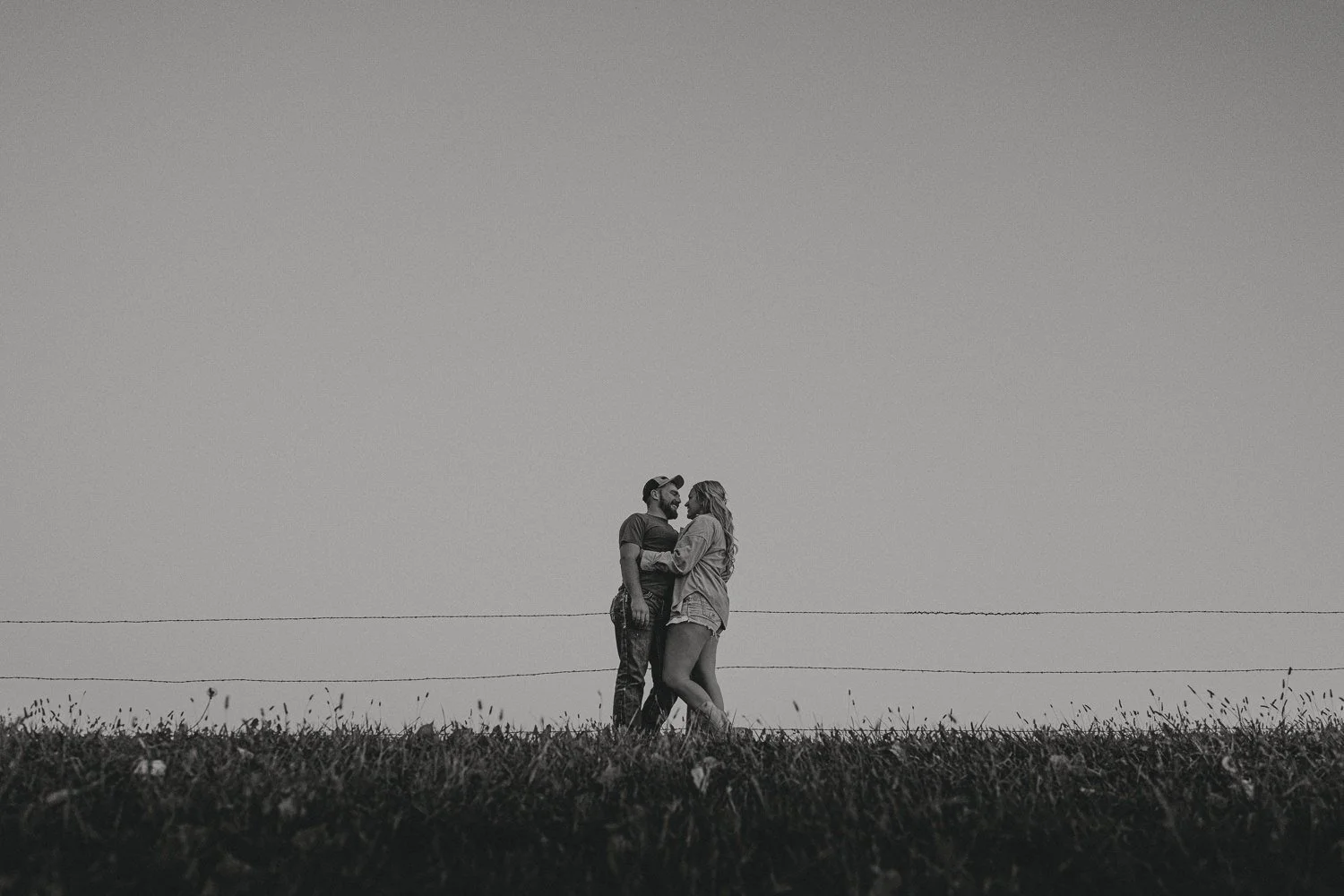 Couples session in open field at sunset