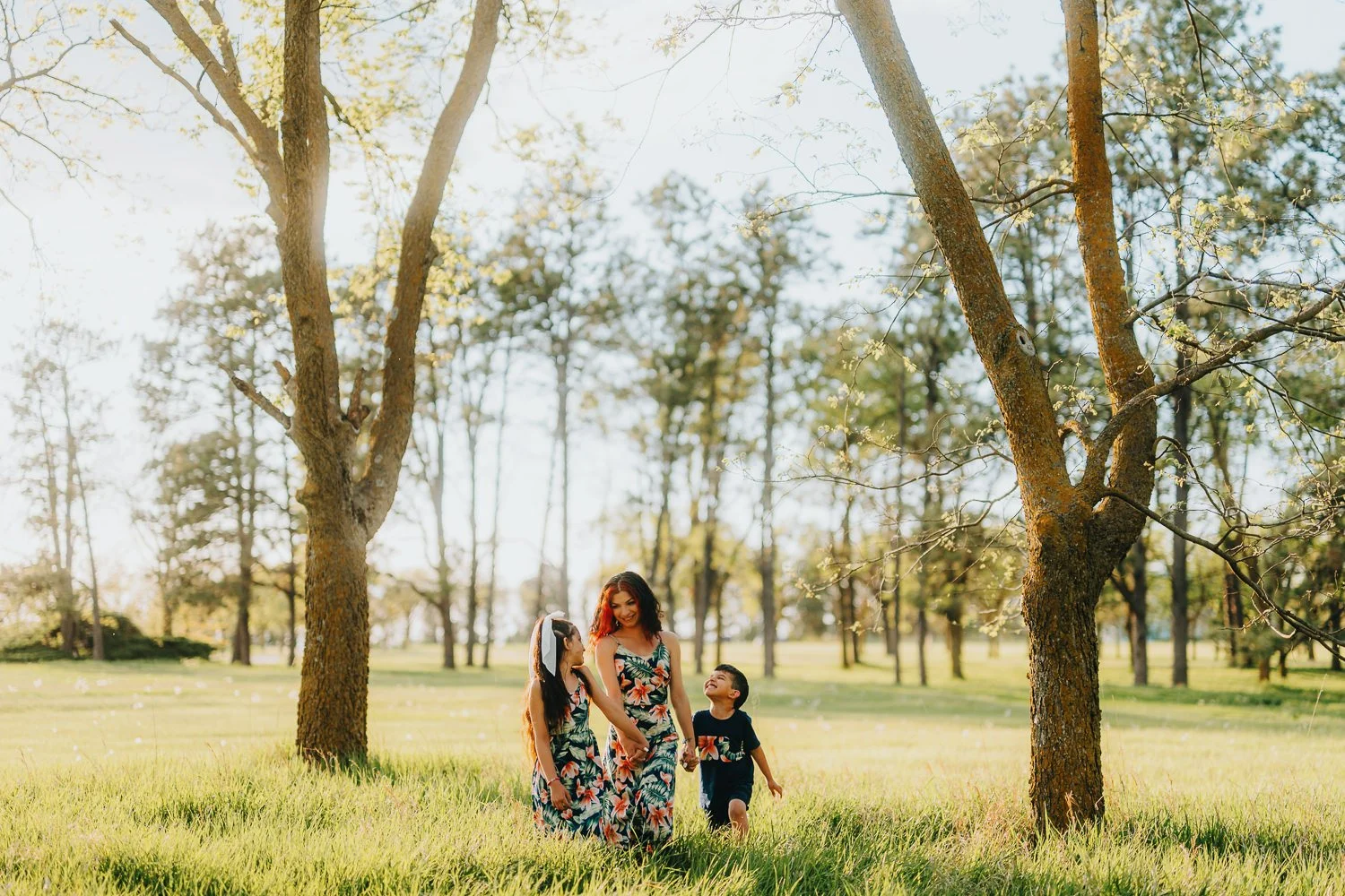 young family walking through a grassy field at Pioneers park in Lincoln Nebraska