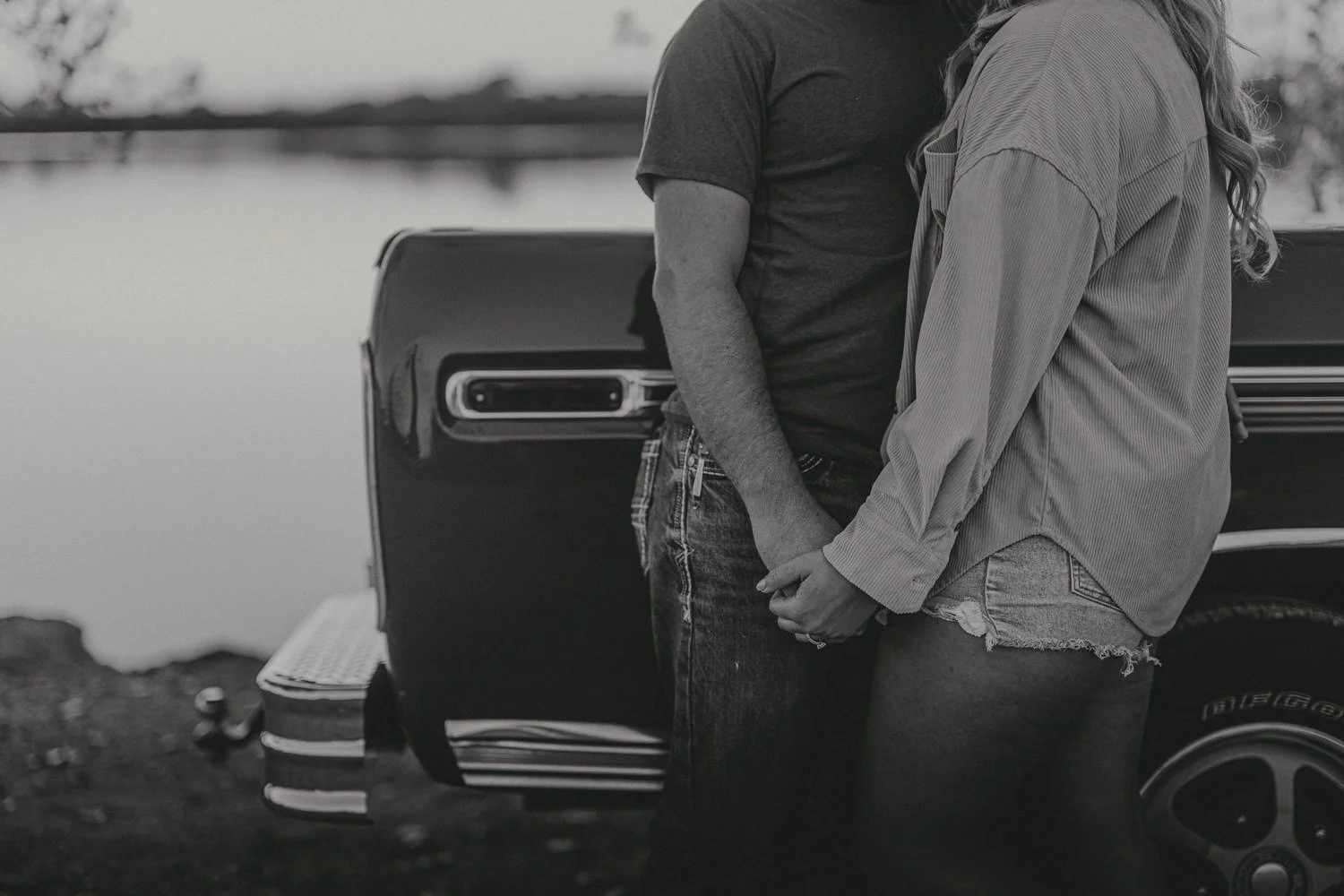 Couples standing by a classic truck at sunset