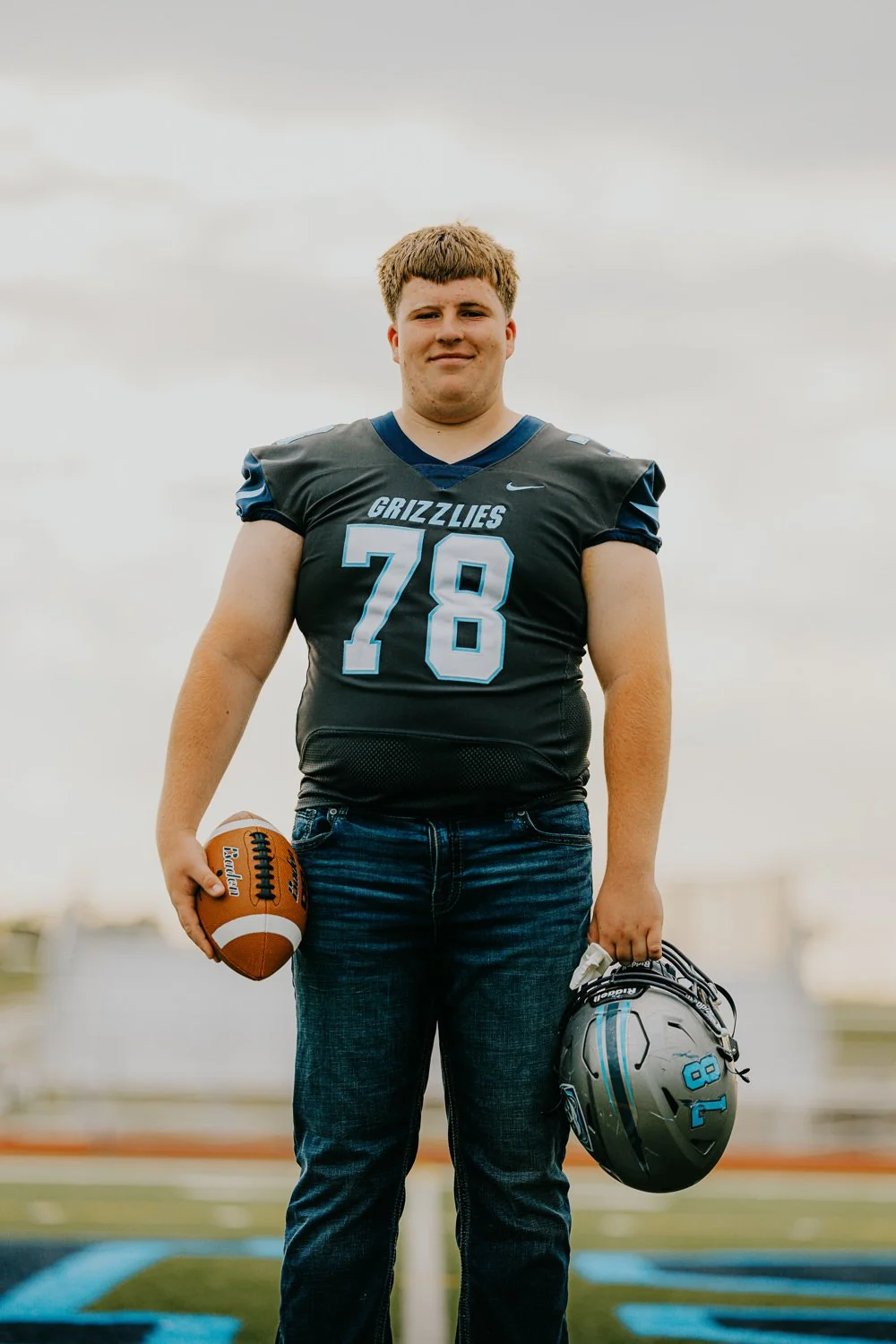 2. High school senior standing on football field during photo session