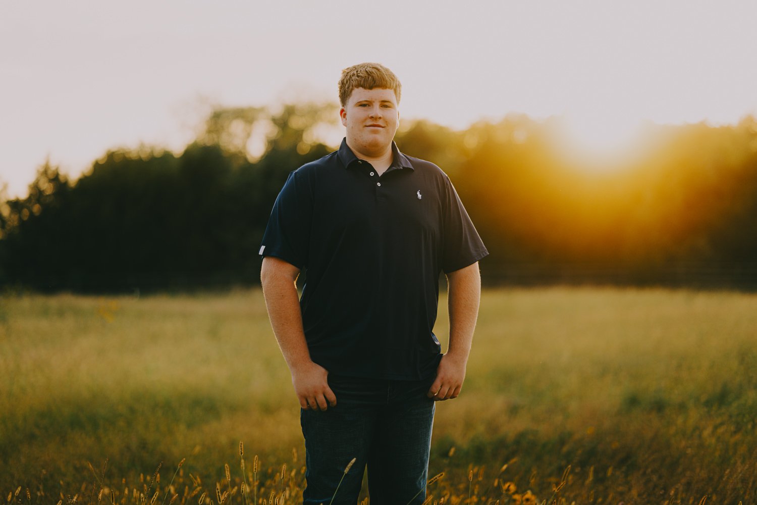 4. Senior photos in an open pasture during golden hour