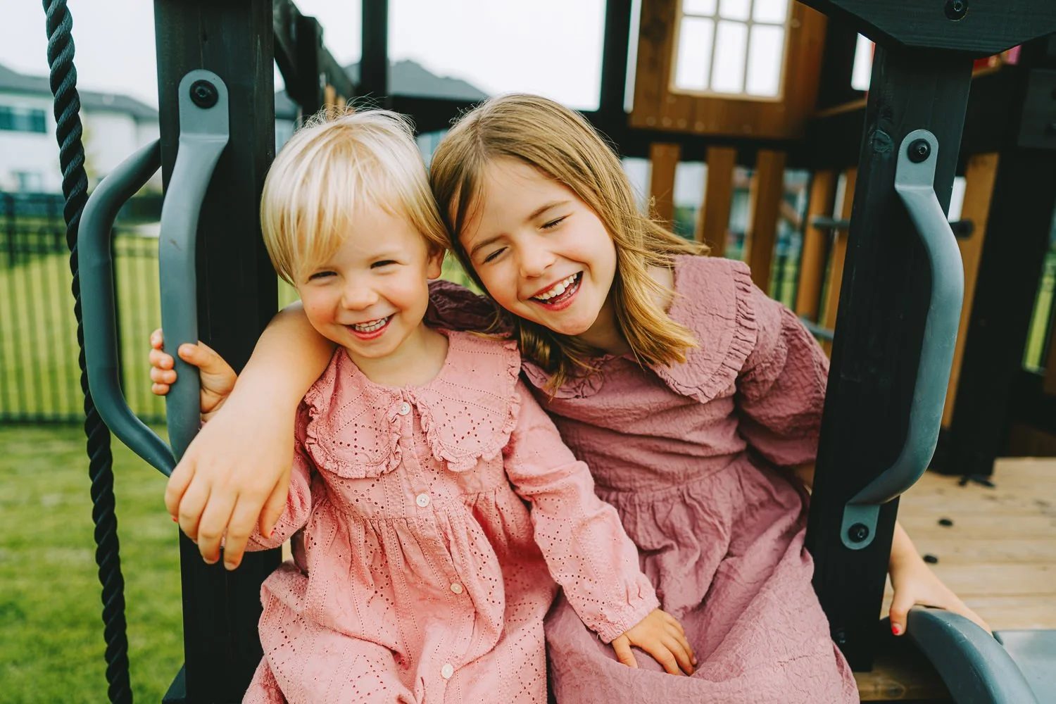 Lincoln family photography of sisters holding hands in backyard.