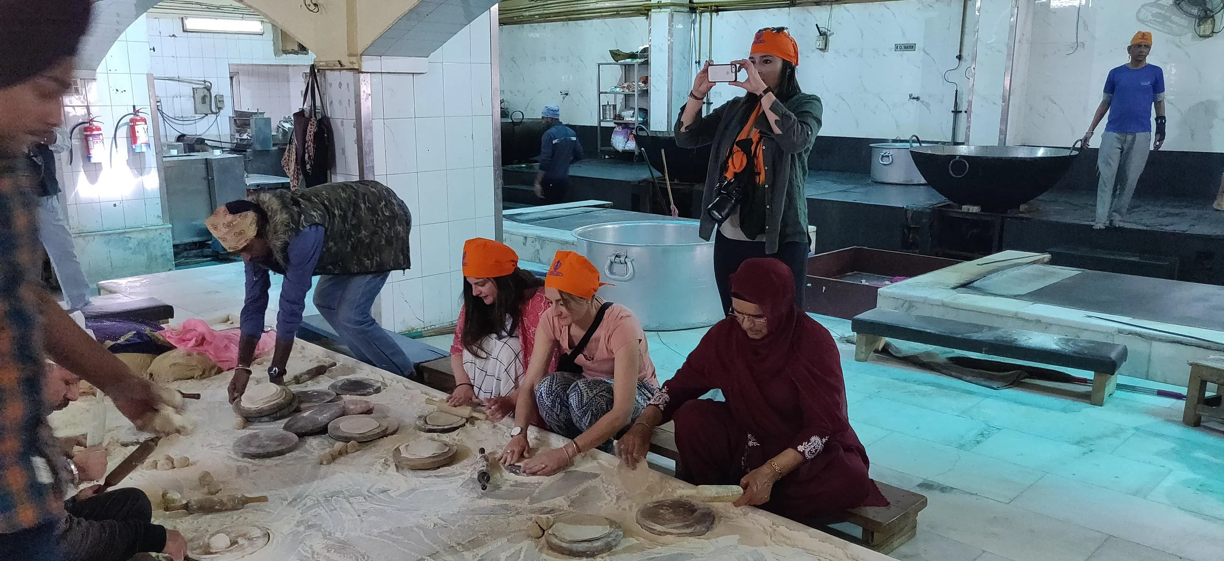 Frivillige laver mad i Gurudwara kitchen, et fælleskøkken, der serverer gratis, vegetariske måltider til alle, uanset deres baggrund. Her spiser gruppen frokost som en del af programmet på den faglige grupperejse med Groossartig.