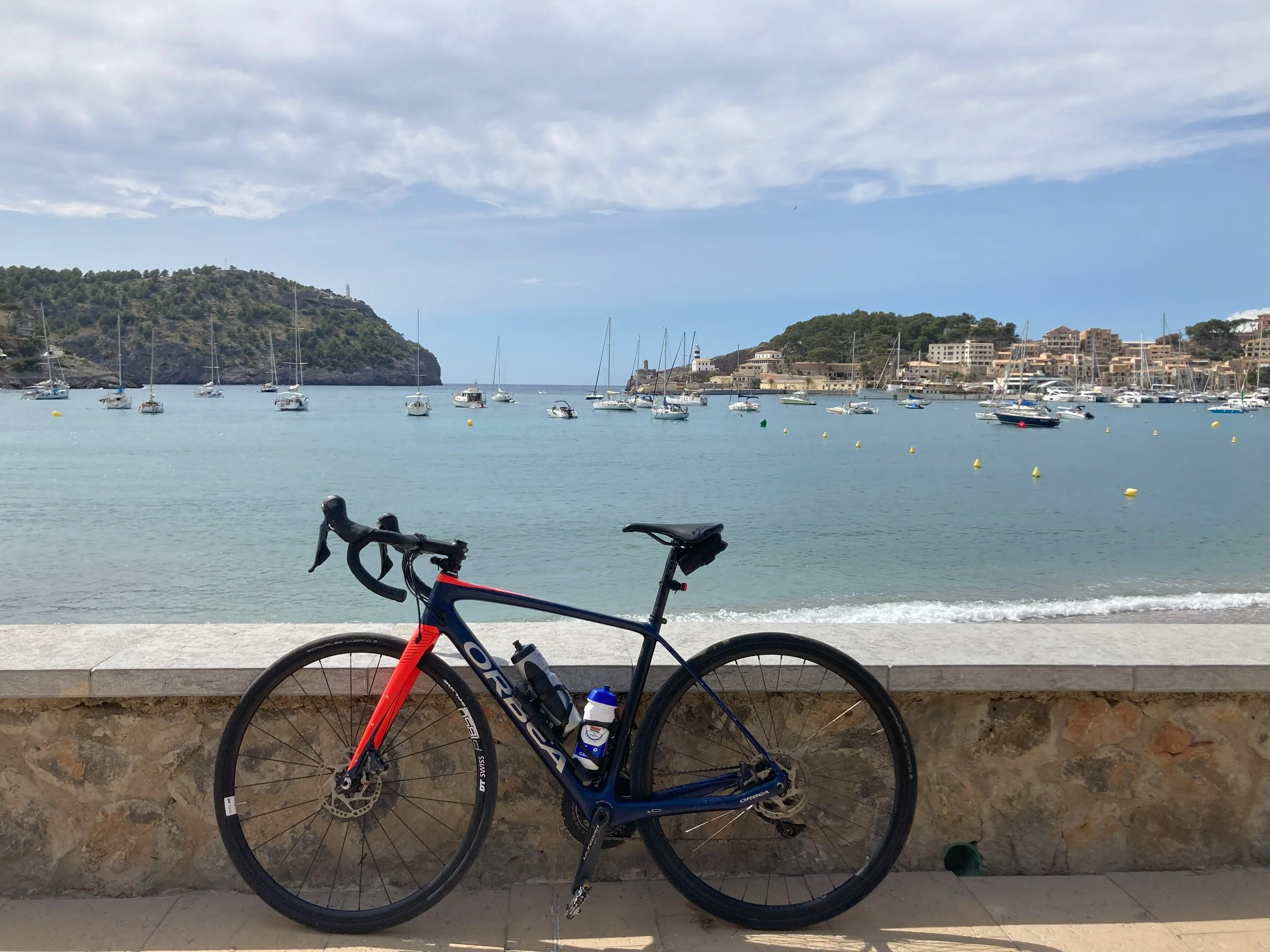 Cykel foran lyseblåt hav med små både på Mallorca