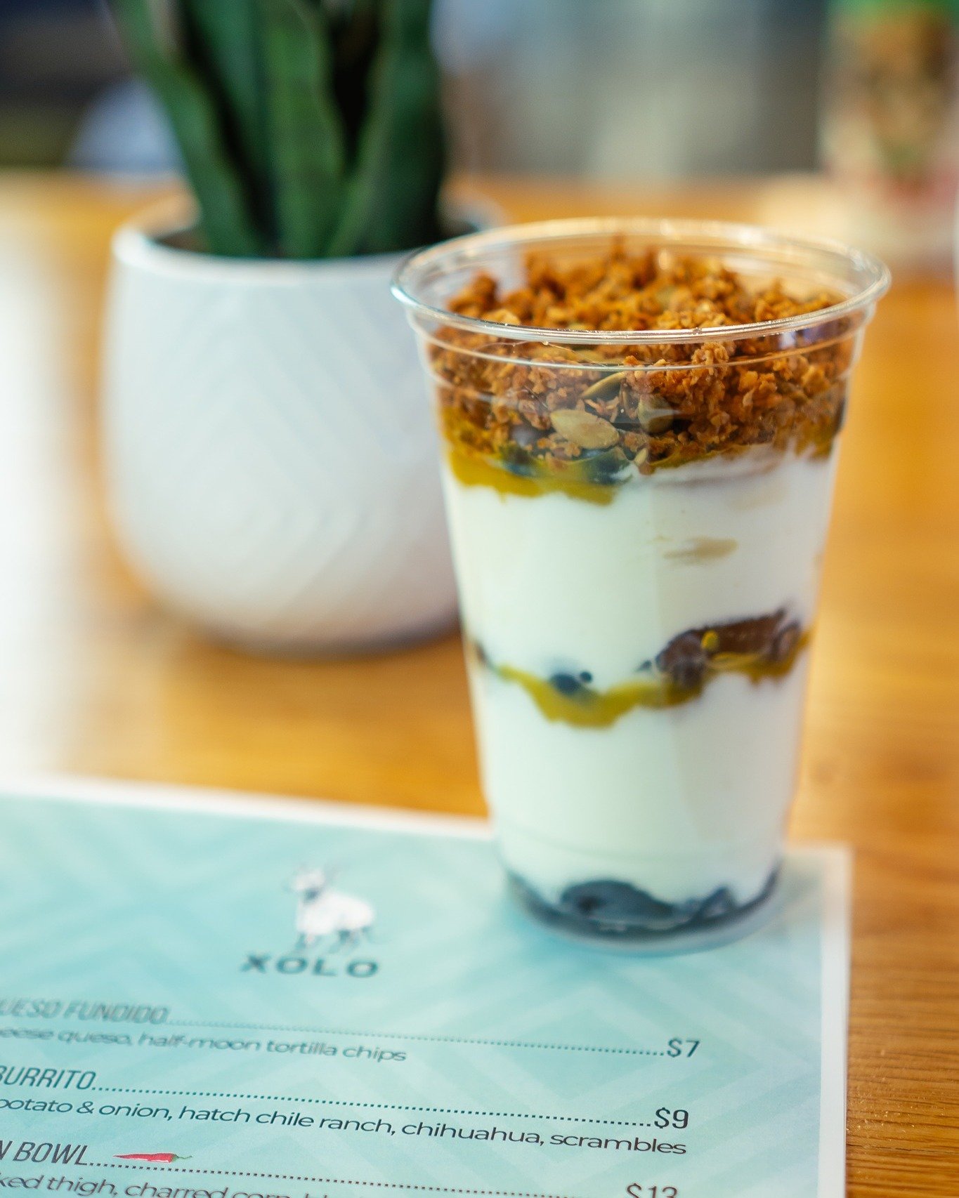 ... And Maybe A Spoon? 🫐🍍 Breakfast before work is important. That's why we have both sit-down + on-the-go options. Grab a spoonful of delight with our heavenly creation: greek yogurt layered with pineapple, blueberry, mango coulis, agave, and Mexi