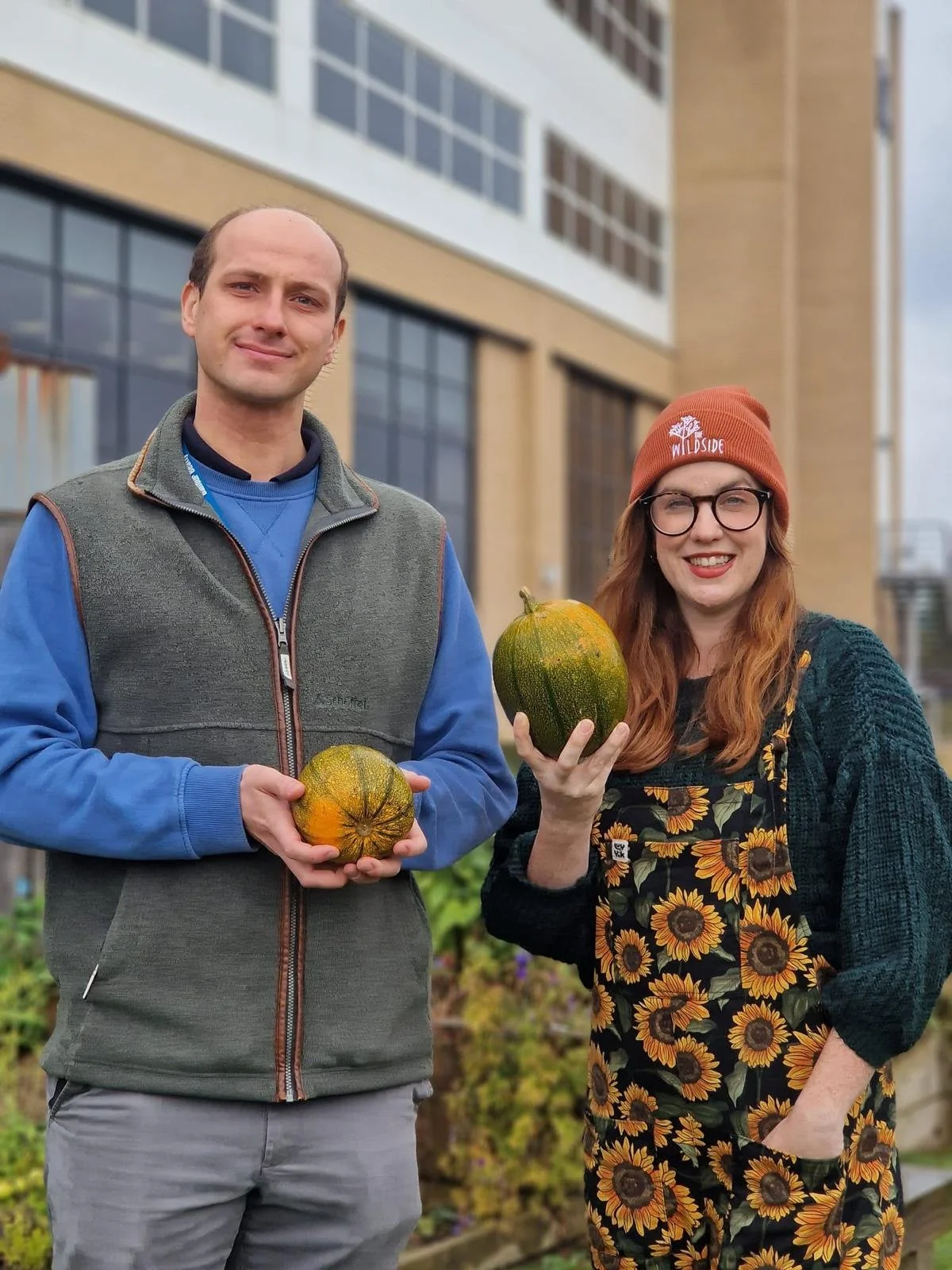 Two people show off pumpkins from the Quroum Allotment