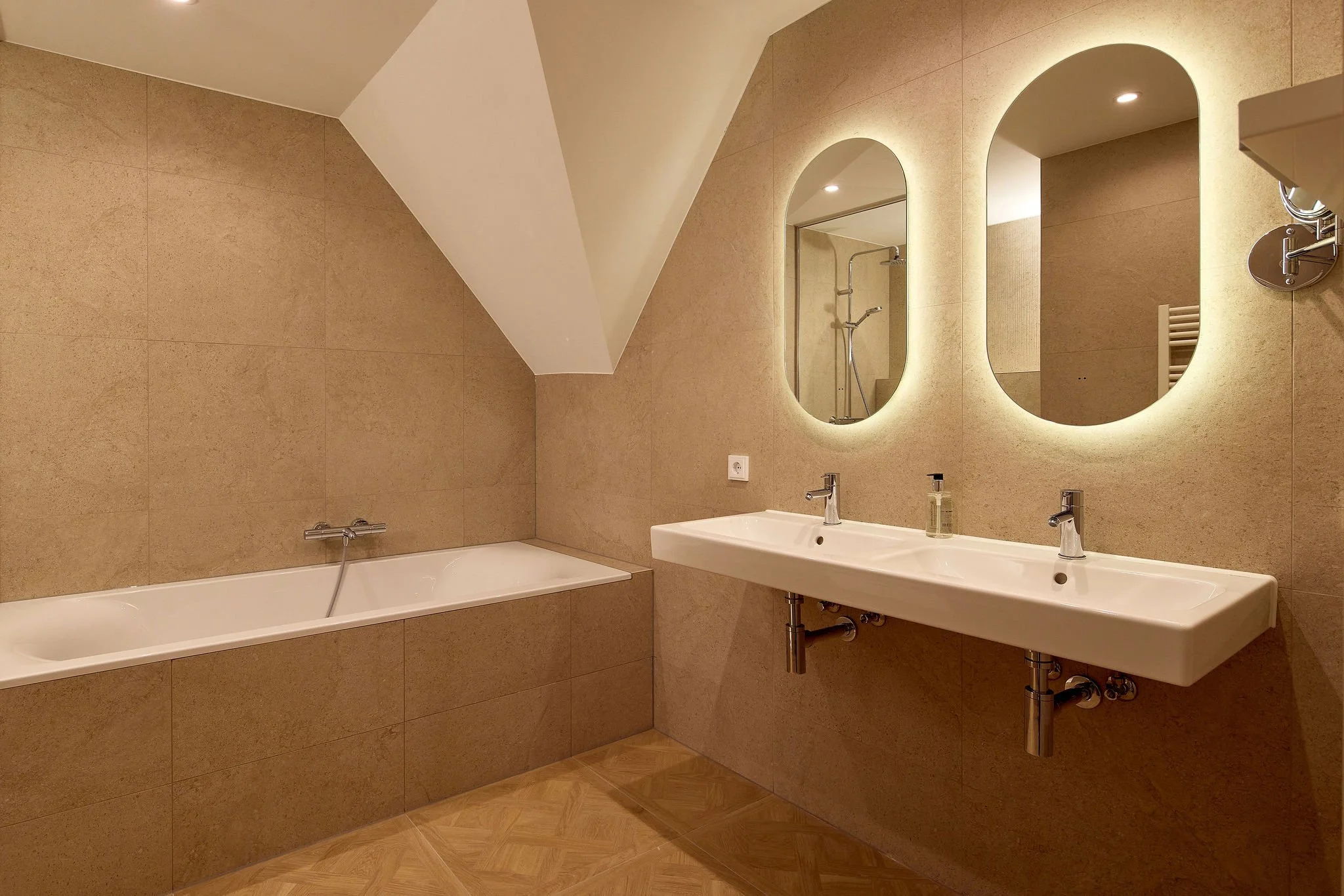 ruime badkamer beige tegels, bad en inloopdouche