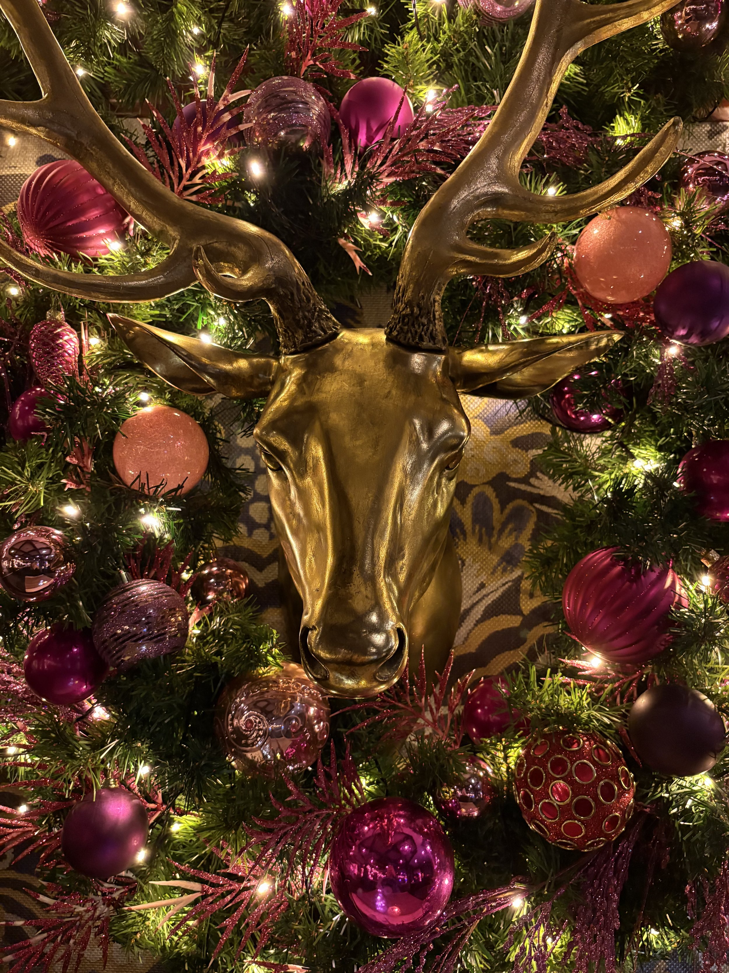 een goud hert versierd met roze kerstballen