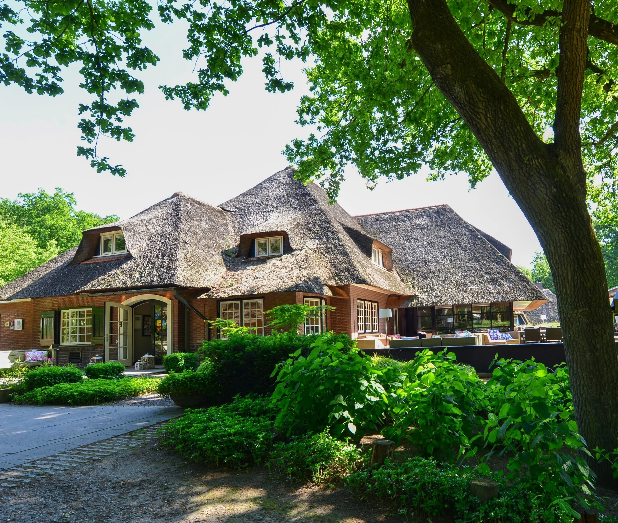 Hotel Hoog Holten buitenaanzicht. De ingang deuren met veel groen van de natuur.