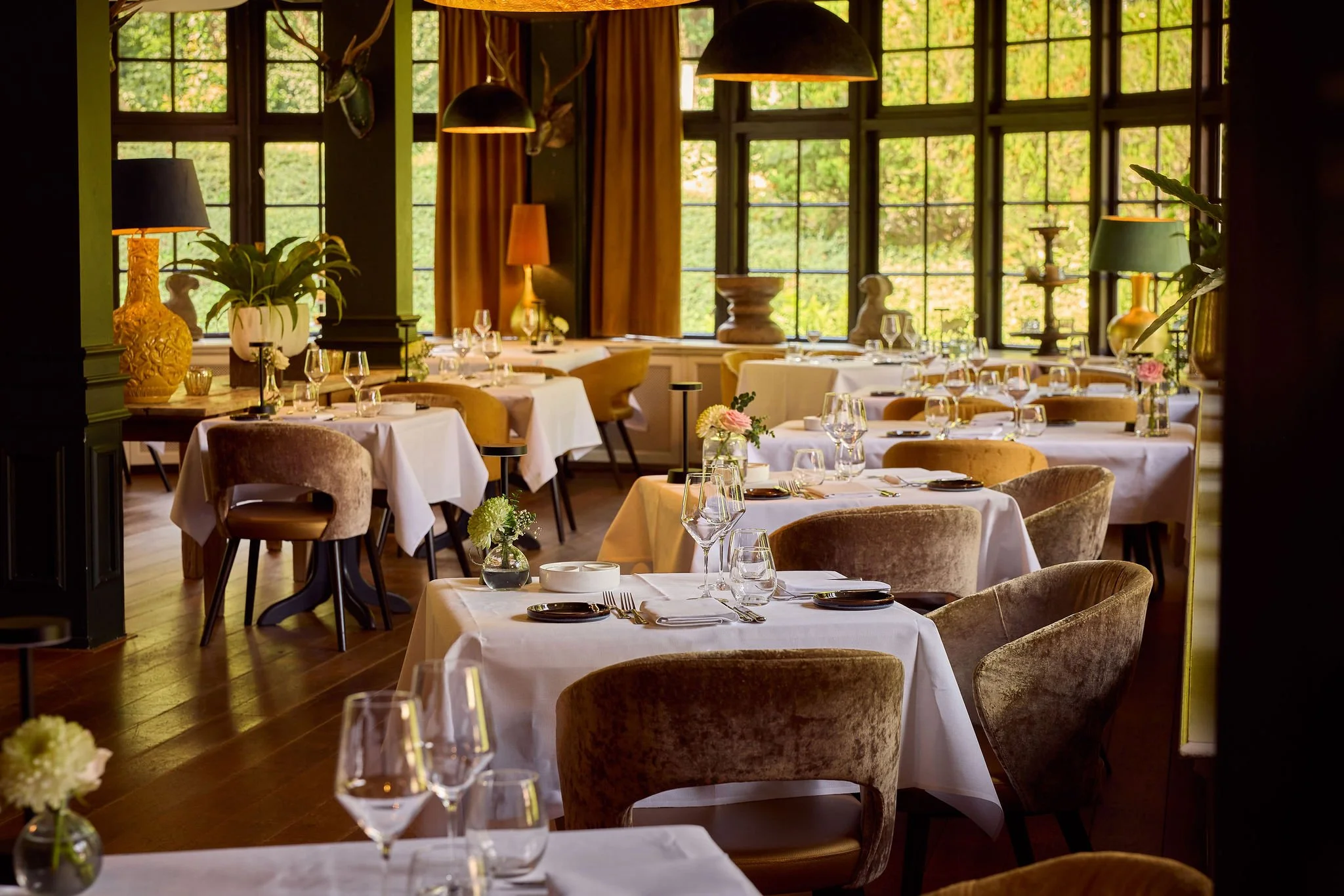 Sfeervol ingedekt restaurant met bestek, glaswerk en linnen